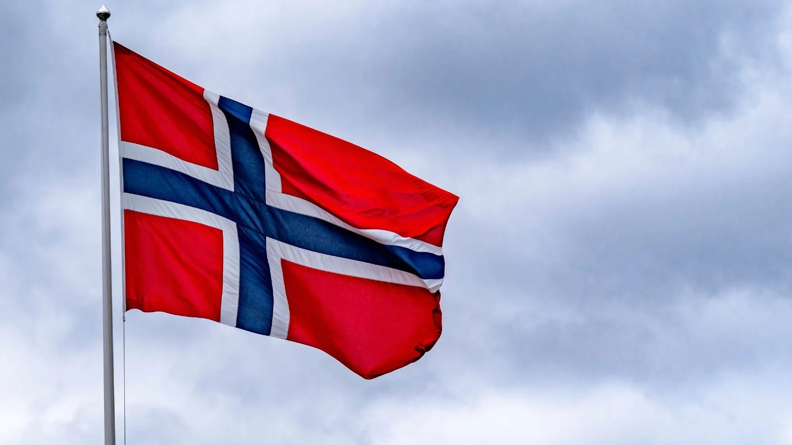 Bandera de Noruega ondeando junto a un gráfico de crecimiento económico y monedas