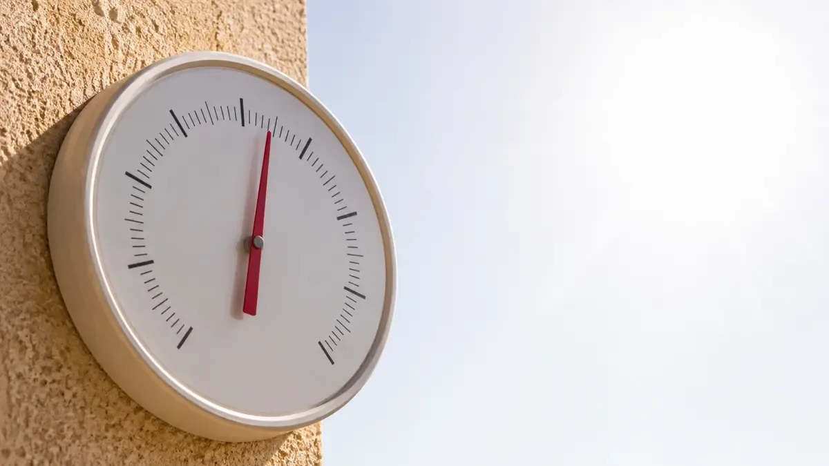Termómetro analógico bajo el sol con la columna alta