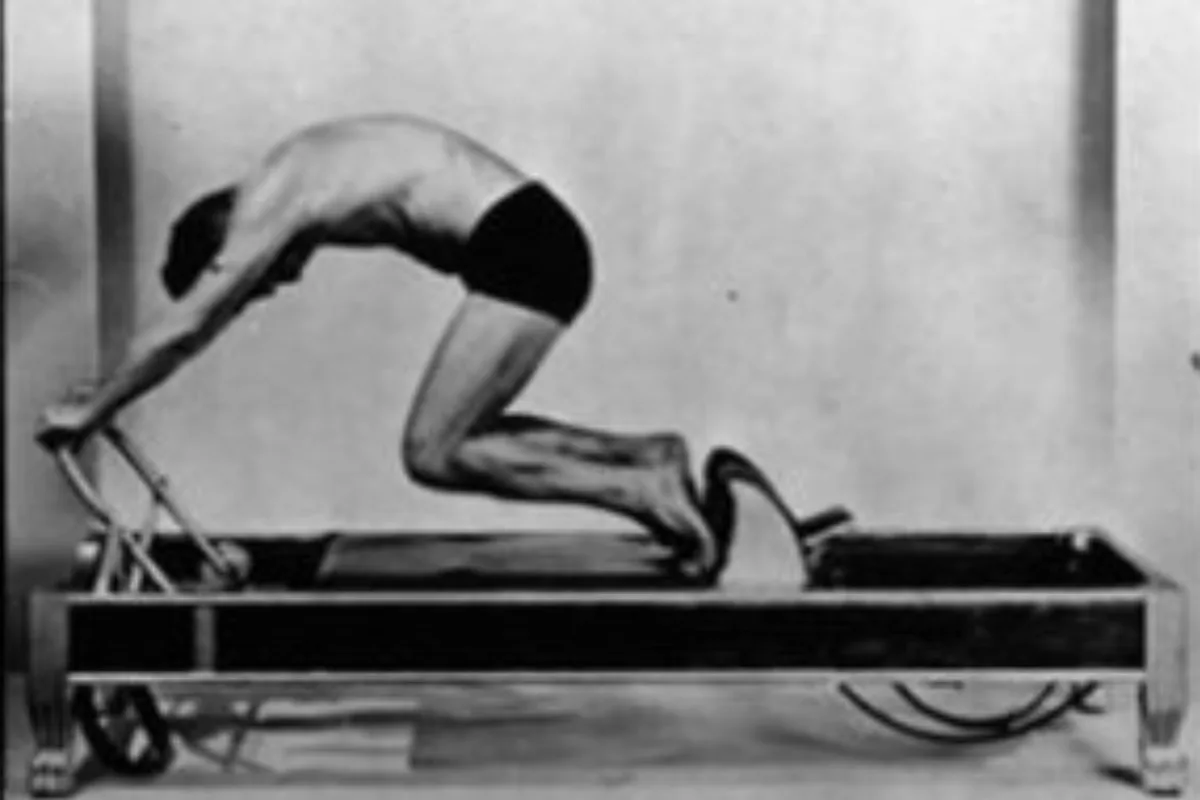 Joseph Pilates en una foto histórica junto a una instructora moderna practicando ejercicios de contrología