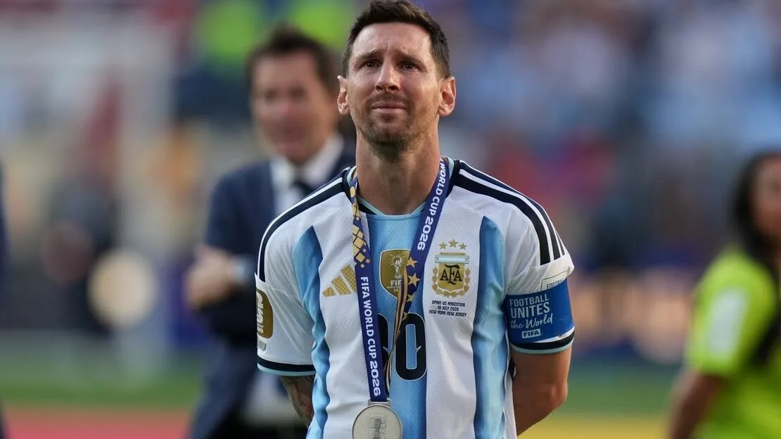 Jugadores de fútbol celebrando en el vestuario sin Lionel Messi, con trofeos y banderas argentinas