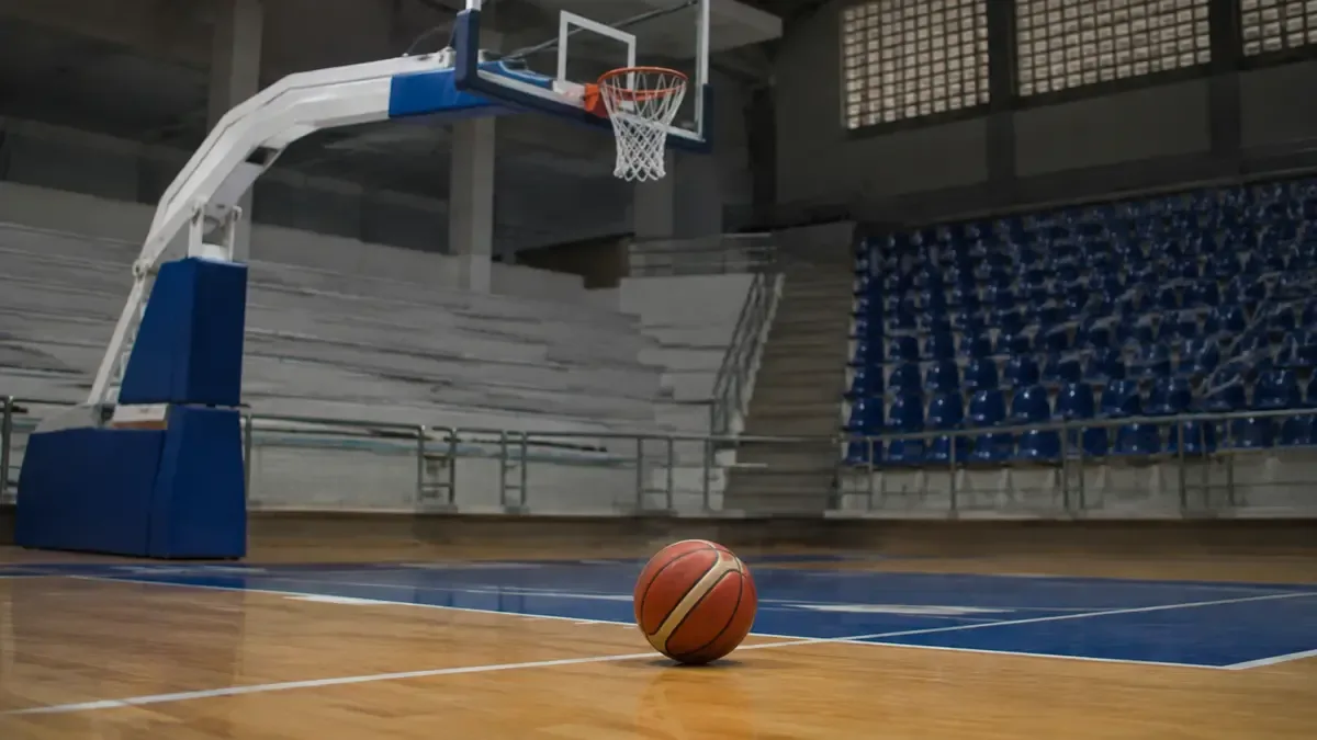 Una pelota de básquet debajo de un aro en un estadio local vacío, vista en tres cuartos, profundidad de campo suave